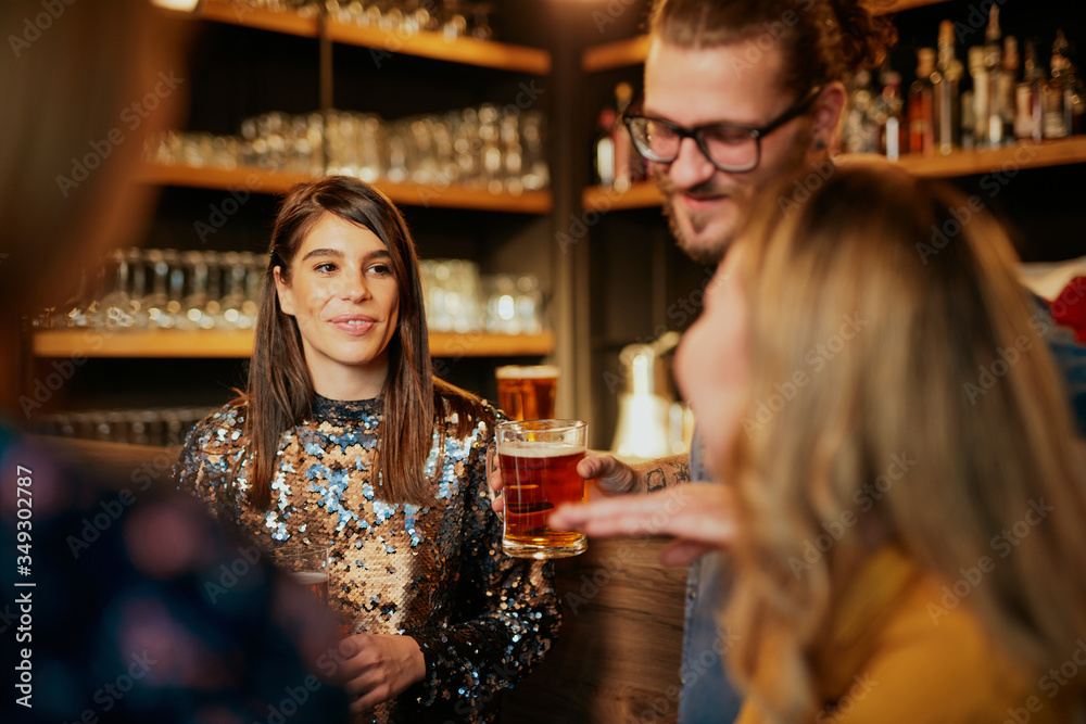Group of best friends standing in bar, chatting and drinking beer. Nightlife concept. Group of best friends standing in bar, chatting and drinking beer. Nightlife concept.