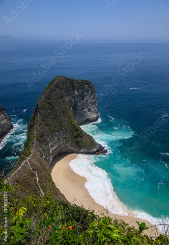 Kelingking beach (Manta bay) a T-Rex head shape cliff on Nusa Penida, Bali. White sandy beach with turquoise waters enclosed by a steep cliff & headland. View from the top of the hill.