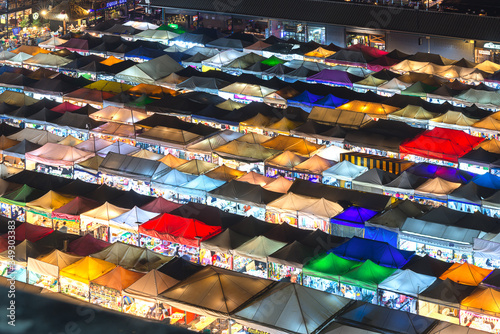 Bangkok, Thailand, Top view of Train Night Market Ratchada  flea market with plenty of shops with colourful canvas and amazing pattern of roofs near MRT line at nighttime in Bangkok