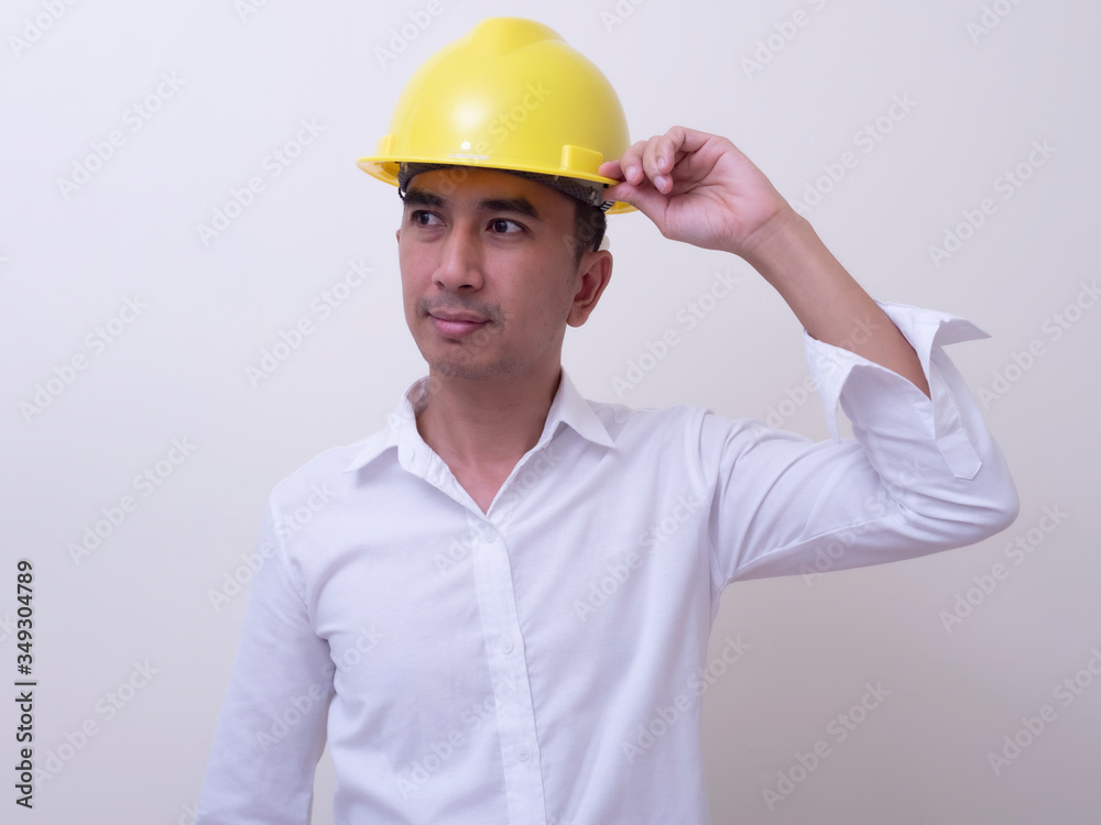 engineer with hands crossed wearing yellow helmet on white background engineer with hands crossed wearing yellow helmet on white background