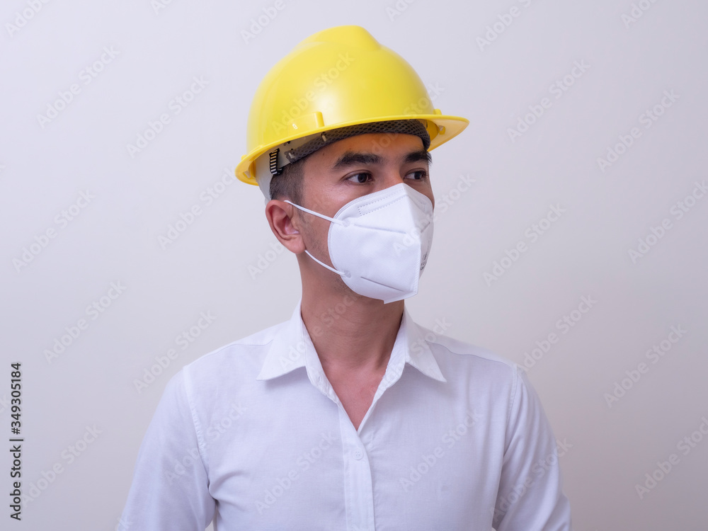 Asian industrial workers wear yellow hard hats, wear protective masks for their health