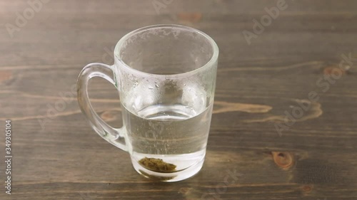 Herbal medicine tablet dissolving in a hot water. Stirring with teaspoon. Sequence of 1 second cuts. Concept for self-medication and natural medicine
