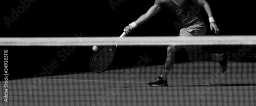 Male tennis player in action on the court on a sunny day. Black and white © Augustas Cetkauskas