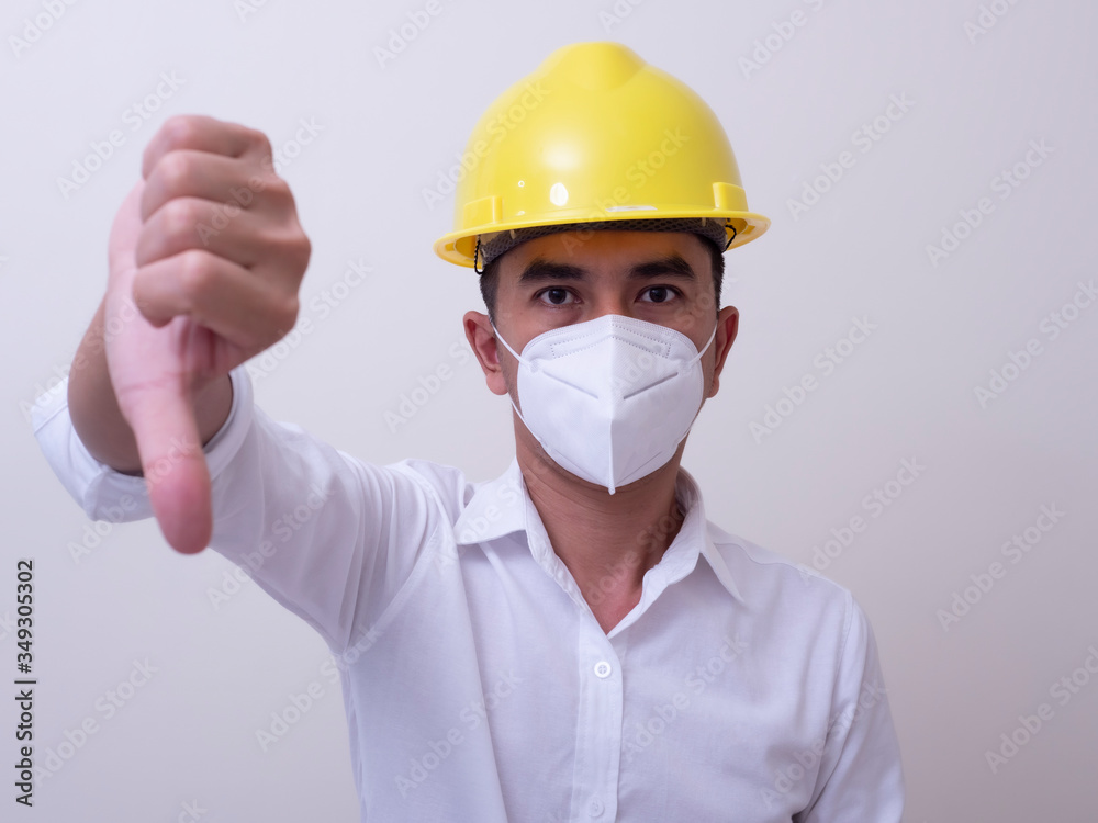 Asian industrial workers wear yellow hard hats, wear protective masks for their health Asian industrial workers wear yellow hard hats, wear protective masks for their health