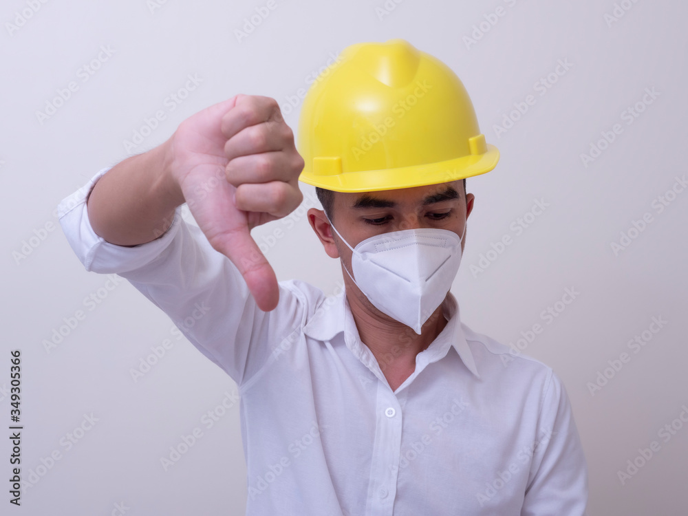 Asian industrial workers wear yellow hard hats, wear protective masks for their health Asian industrial workers wear yellow hard hats, wear protective masks for their health