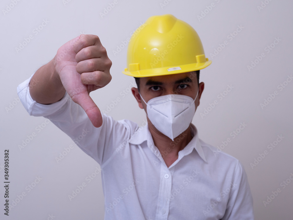 Asian industrial workers wear yellow hard hats, wear protective masks for their health Asian industrial workers wear yellow hard hats, wear protective masks for their health