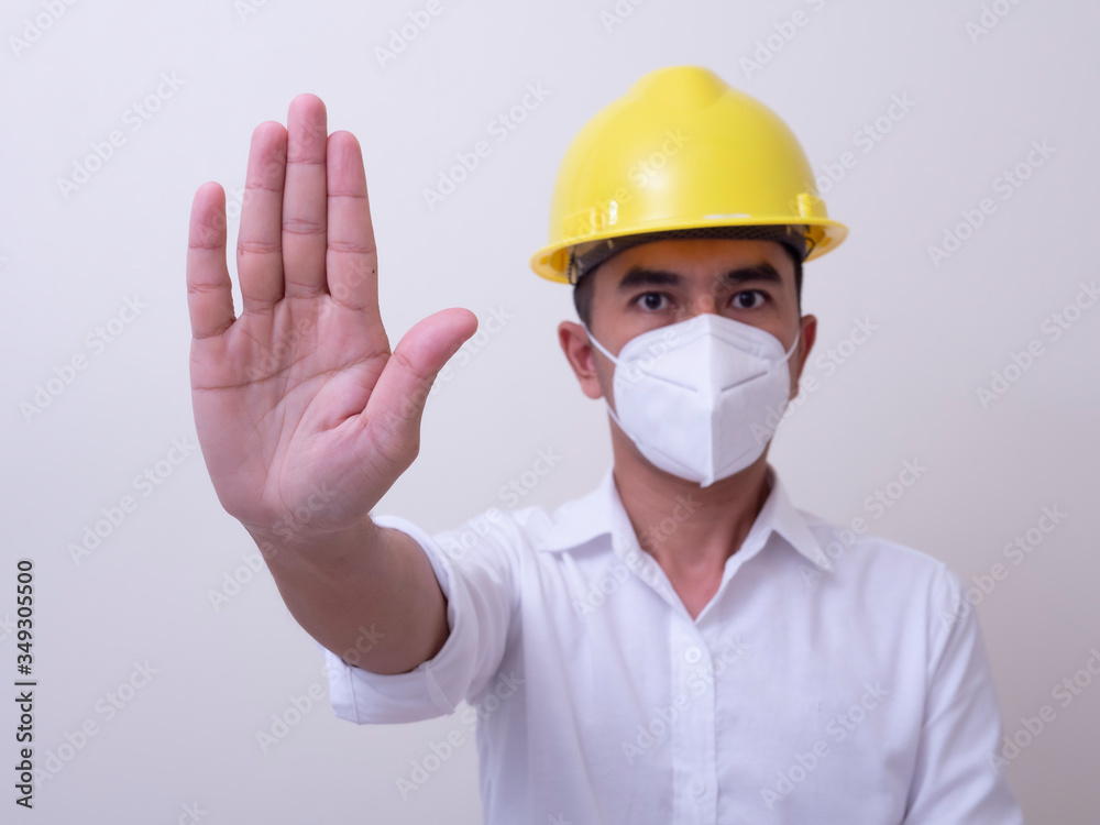 Asian industrial workers wear yellow hard hats, wear protective masks for their health Asian industrial workers wear yellow hard hats, wear protective masks for their health