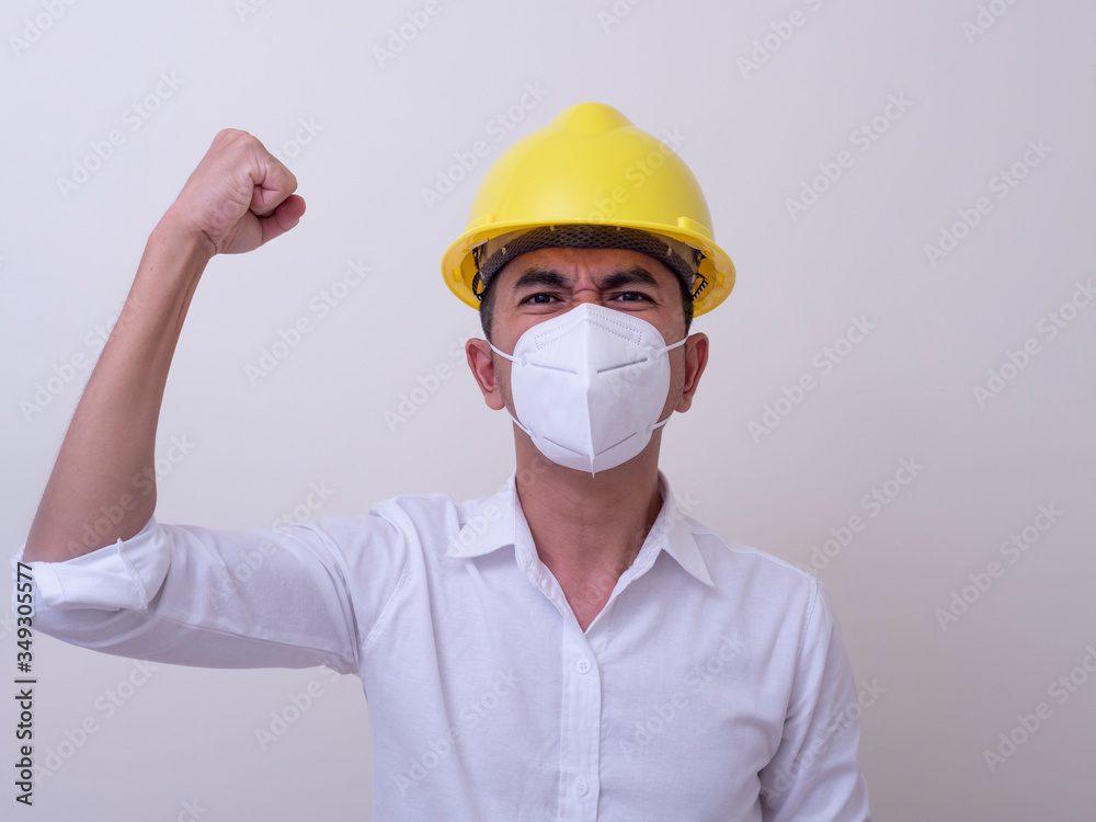 Asian industrial workers wear yellow hard hats, wear protective masks for their health Asian industrial workers wear yellow hard hats, wear protective masks for their health