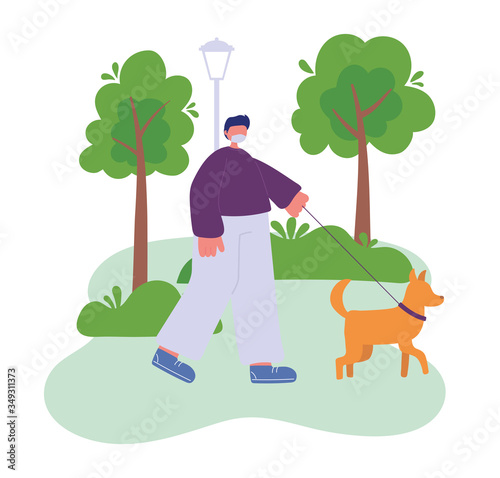 young man with medical mask walking her dog in the park