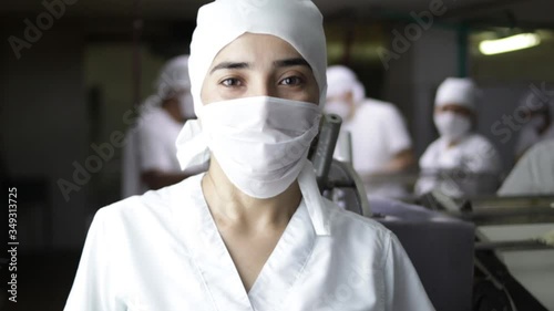 Woman with mask in factory and background out of focus