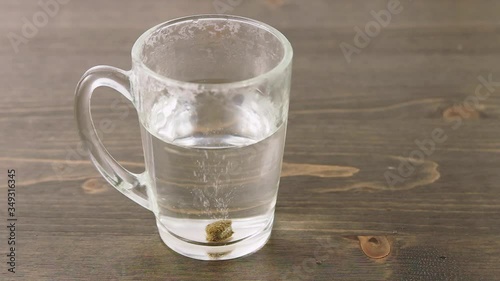 Herbal medicine tablet dissolving in a hot water. Stirring with teaspoon. Concept for self-medication and natural medicine
