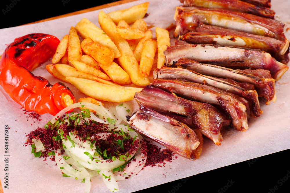 Ribs on the grill, pepper, tomato, French fries, onion on wooden Board
