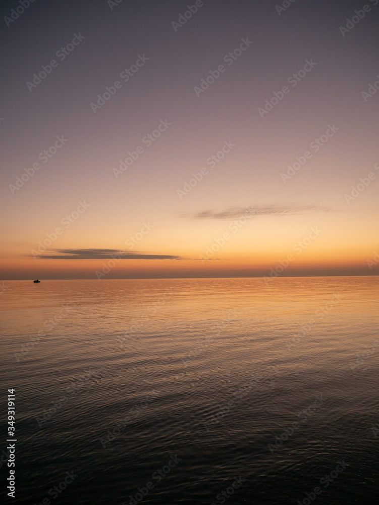 Naklejka premium Sunset on small waves seaside beach