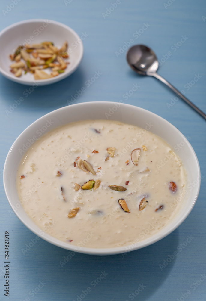 Kheer or Payasam is a type of rice pudding from the Indian subcontinent, made by boiling milk and sugar and is flavoured with dry fruits and nuts, served in ceramic bowl.