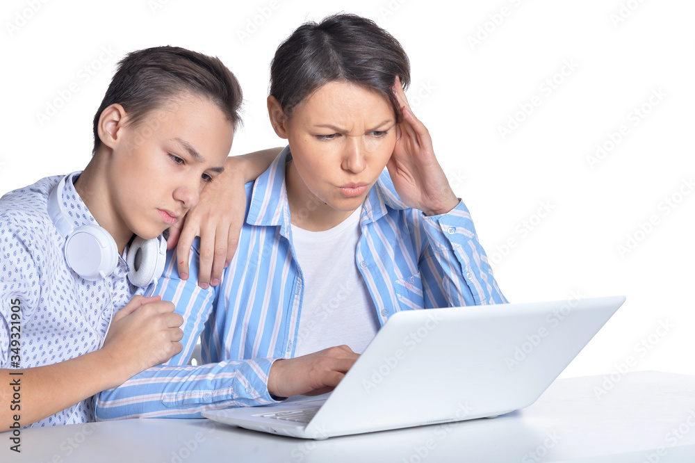 Portrait of sad mother and son using laptop posing against white Portrait of sad mother and son using laptop posing against white
