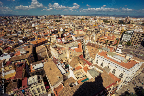 Scenic view from the height of the cathedral in the center of Valencia. Many tile roofs on a background of bright clouds. Typical landscape of Spain