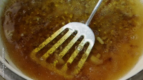 Dirty greasy pan with a spatula. Stirring droplets of oil mixed with water