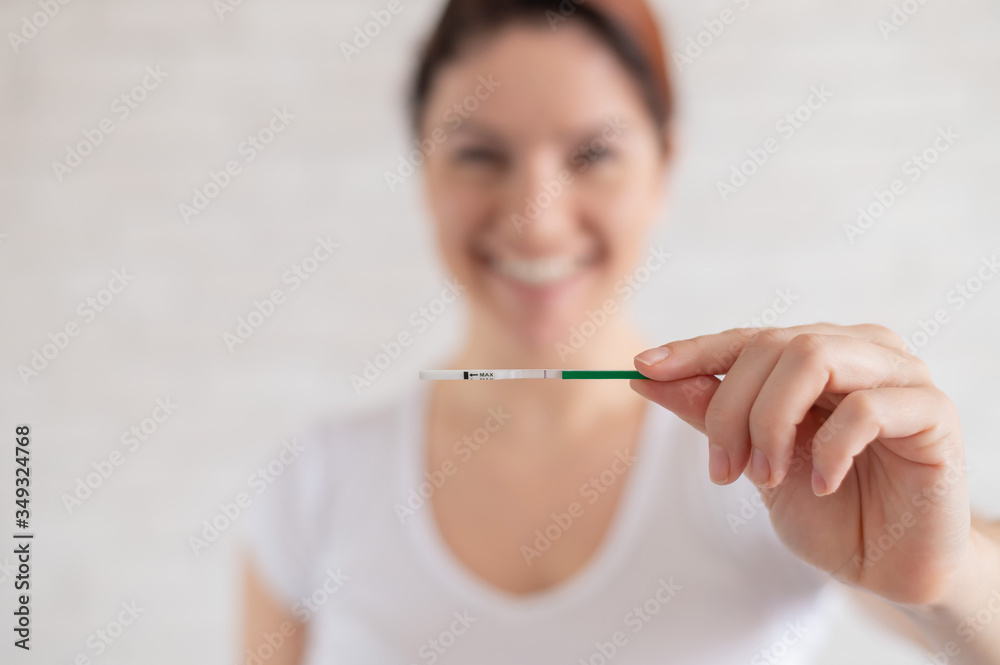 Happy woman shows a negative pregnancy test. The concept of female fertility. Human chorionic gonadotropin. One strip child free. Happy woman shows a negative pregnancy test. The concept of female fertility. Human chorionic gonadotropin. One strip child free.