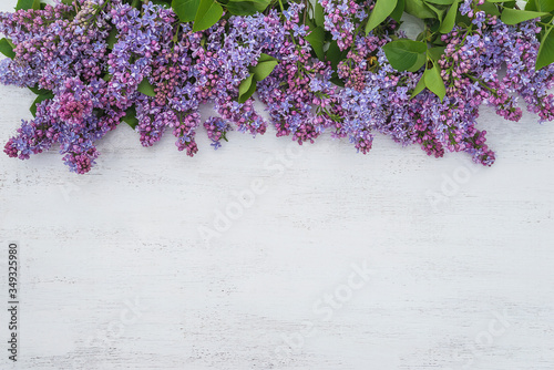 Happy Mothers Day greeting card. Bunch of purple lilac on the white paint wooden background. Copy space, flat lay