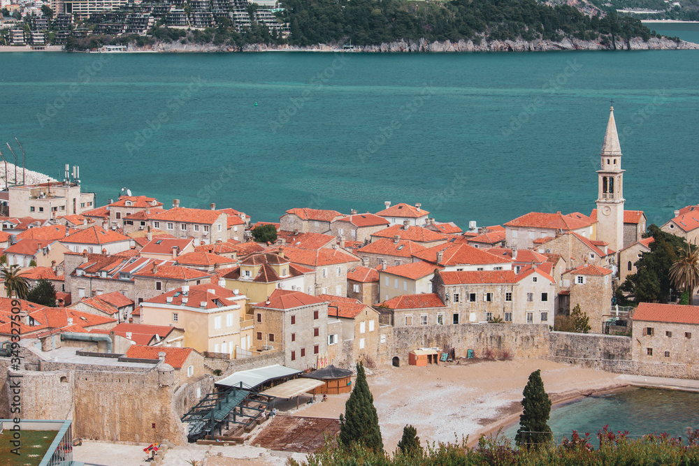 View of the Old Town of Budva. The orange roofs of the ancient city. Bay and beach near the stone walls