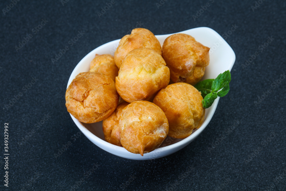 Sweet tasty profiteroles heap in the bowl Sweet tasty profiteroles heap in the bowl