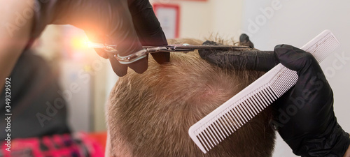 Hair cutting with scissors in a barbershop