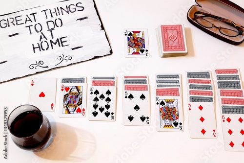 to do at home solitaire game with glasses on white background motivation for quaratine photo