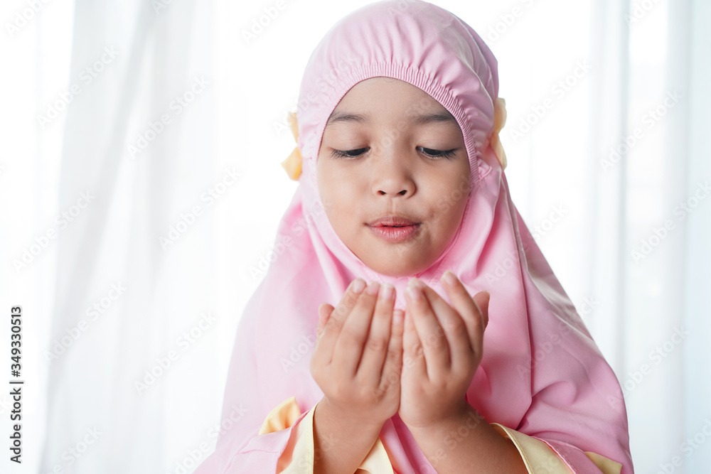 Religious Asian muslim child girl in Muslim hijab dress is praying to the Allah or God. Religious Asian muslim child girl in Muslim hijab dress is praying to the Allah or God.