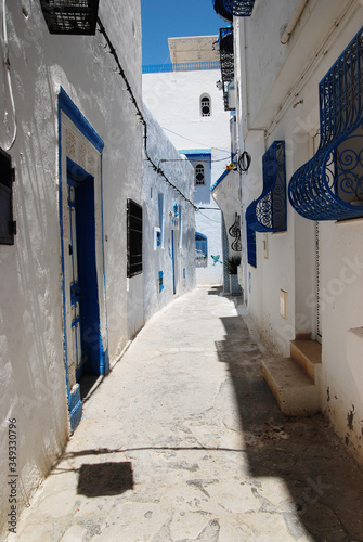 Narrow old street in the eastern city with white and blue houses
