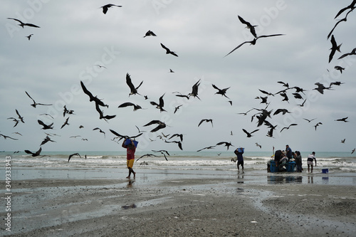 Fisherman walks carrying fish box photo