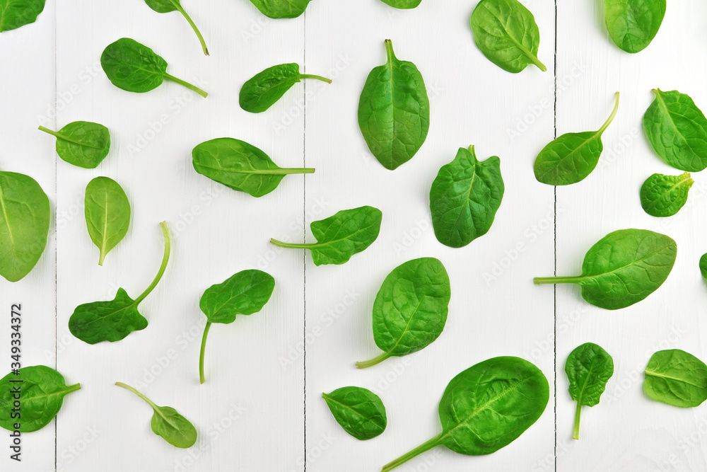 Spinach leaves pattern on white wooden table background. Healthy vegan food trend. Vegan lifestyle concept. Top view. Spinach leaves pattern on white wooden table background. Healthy vegan food trend. Vegan lifestyle concept. Top view.