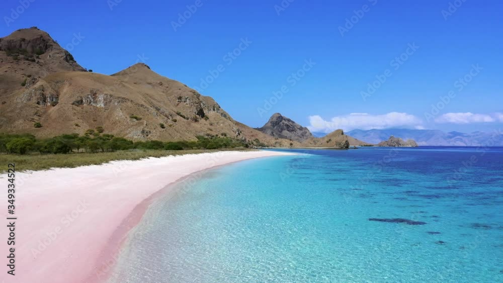 flying over the pink beach with blue water in indonesia