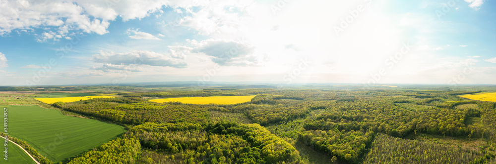 Scenic landscape of countryside from bird's eye view, springtime. Aerial drone view of woodland and farmland