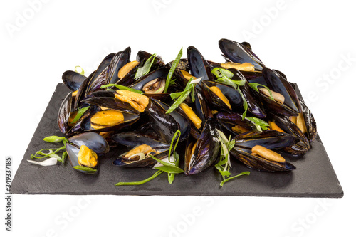 Gourmet Mussels Natur on a black stone plate, isolated on white background