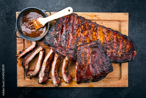 Gegrillte Kalbs Spare Loin Ribs St Louis Cut mit scharfer Honig Chili Marinade als als Draufsicht auf einem rustikalen Holz Schneidebrett 