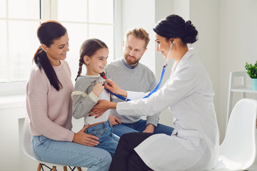 Happy family on a visit to the doctor in the office of a doctor.