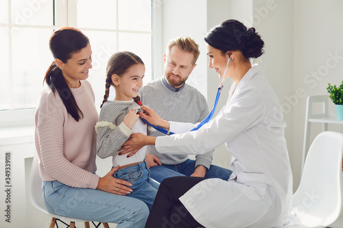 Happy family on a visit to the doctor in the office of a doctor. photo