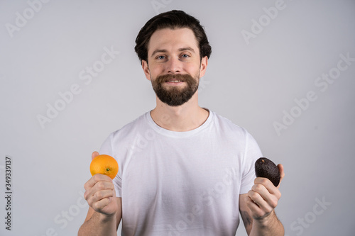 Man with long beard eat lemon. Fruit and healthy organic food. Dieting and fitness. Vitamin citrus at hipster on yellow background. Vegetarian, copy space