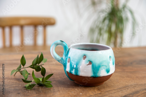 Fototapeta Naklejka Na Ścianę i Meble -  colorful handmade ceramic coffee cup on wooden table 