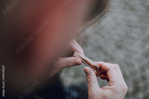 Cropped photo of male holding cigarette outdoors