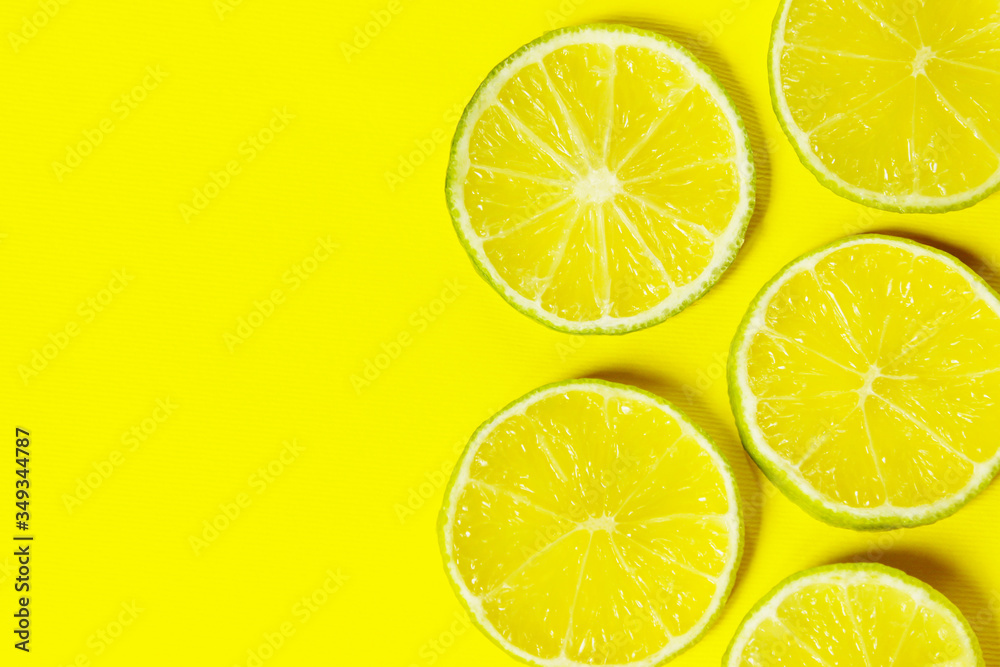 Sliced lime on right side of yellow background. Colorful food background, horizontal view. Sliced lime on right side of yellow background. Colorful food background, horizontal view.