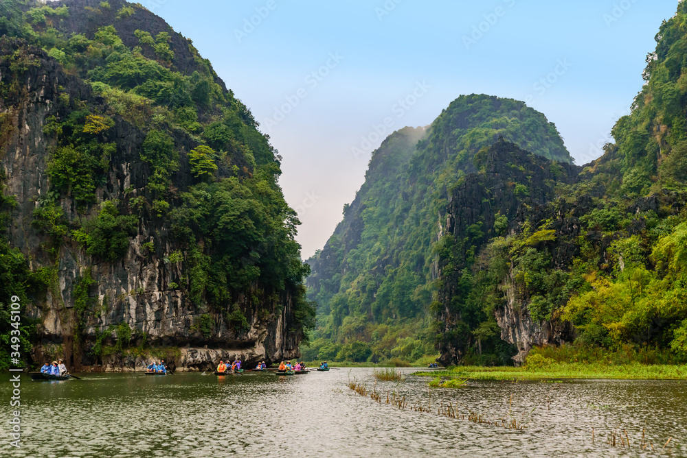 Tam Coc Natioanl Park - Vietnamese Girl traveling in boat along the Ngo Dong River at Ninh Binh Province, Trang An landscape complex, Landscape formed by karst towers and rice fields - Vietnam