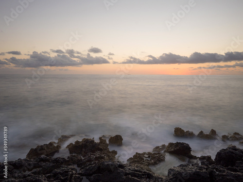 Sunset and waves crashing on the rocks