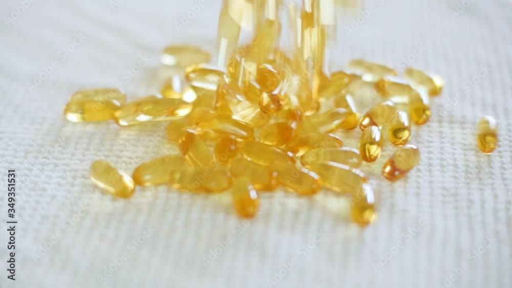 A whole bunch of yellow gel pills dropping in slow motion A whole bunch of yellow gel pills dropping in slow motion