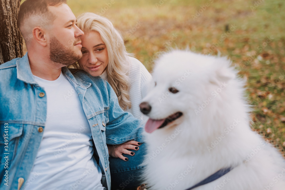 Couple with samoyed breed puppy are enjoying their weekend Couple with samoyed breed puppy are enjoying their weekend