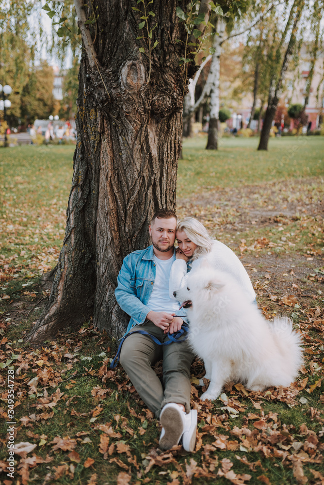 Young couple are relaxing outdoors with their cute dog Young couple are relaxing outdoors with their cute dog
