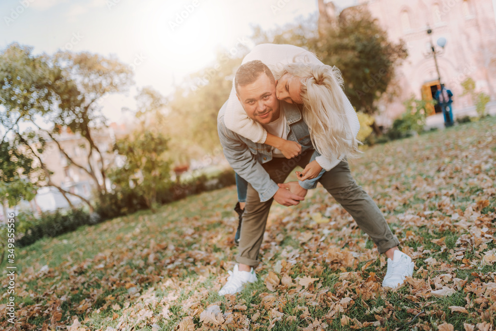 Fototapeta premium Happy young man and woman having fun in autumn park
