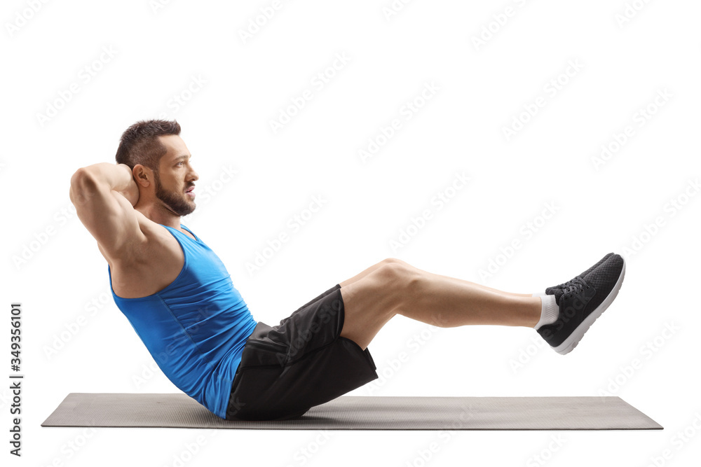 Fit young man exercising abs on a mat Fit young man exercising abs on a mat