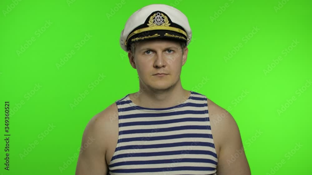 Young sailor man salutes with hand to camera. Seaman guy in sailor's vests Young sailor man salutes with hand to camera. Seaman guy in sailor's vests