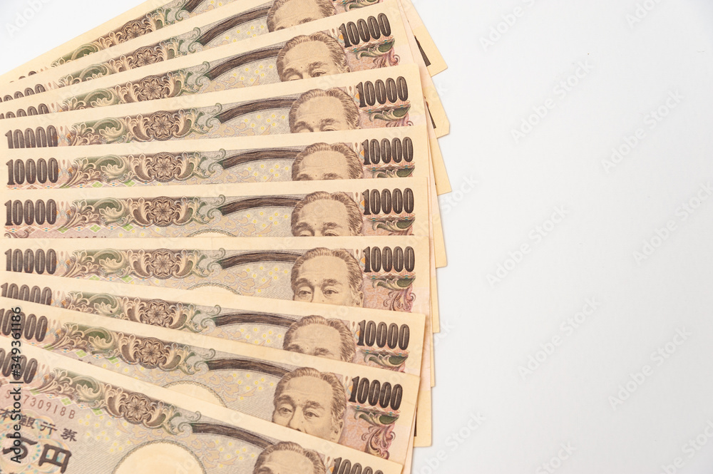 Close-up of 100,000 yen stacked in layers of 10,000 yen banknotes. Isolated on white background. Copy space. Horizontal shot. Close-up of 100,000 yen stacked in layers of 10,000 yen banknotes. Isolated on white background. Copy space. Horizontal shot.